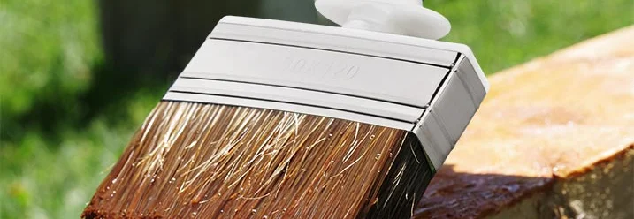 Pinsel trägt Lasur auf Holz auf